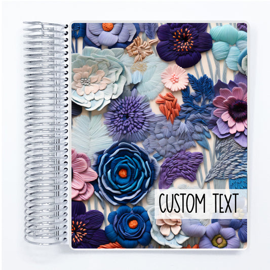 a spiral notebook with a flower design on it