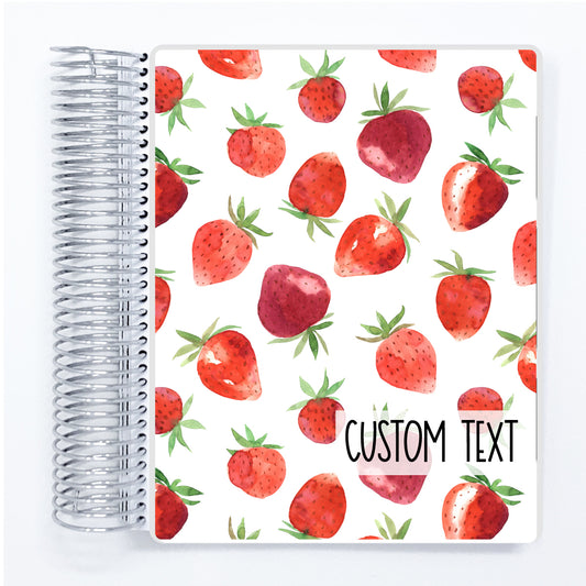 a notebook with a pattern of strawberries on it
